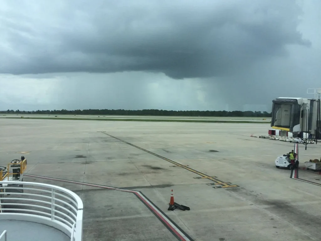 Fuerte rayo de lluvia de una tormenta oscura sobre el aer&oacute;dromo del Aeropuerto Internacional de Orlando, visto desde una puerta