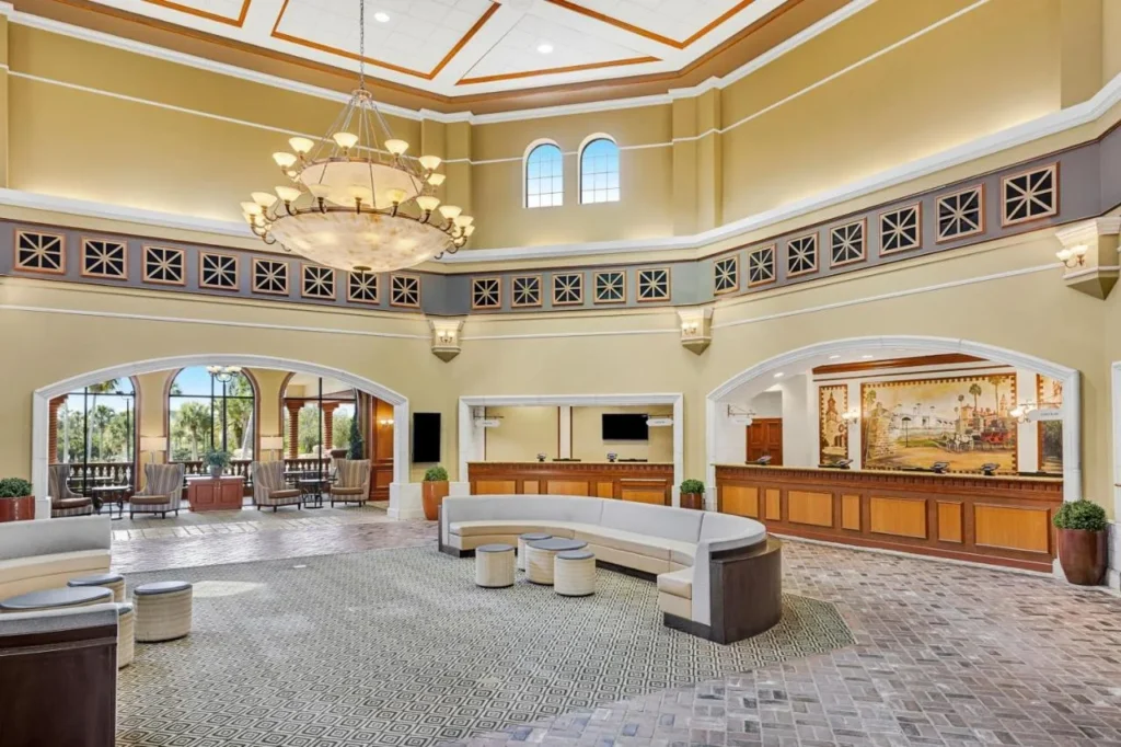 Lobby de techos altos con candelabro, sof&aacute; curvo y recepci&oacute;n en Sheraton Vistana Villages