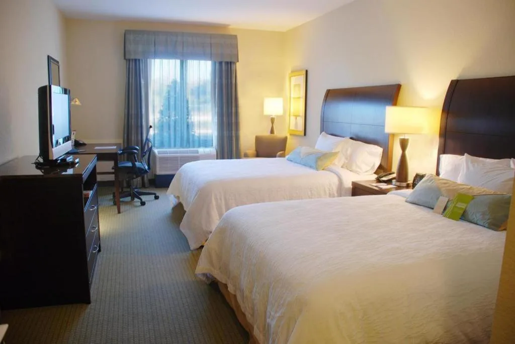 Hilton Garden Inn Lakeland habitación con dos camas queen, una cómoda, TV y escritorio