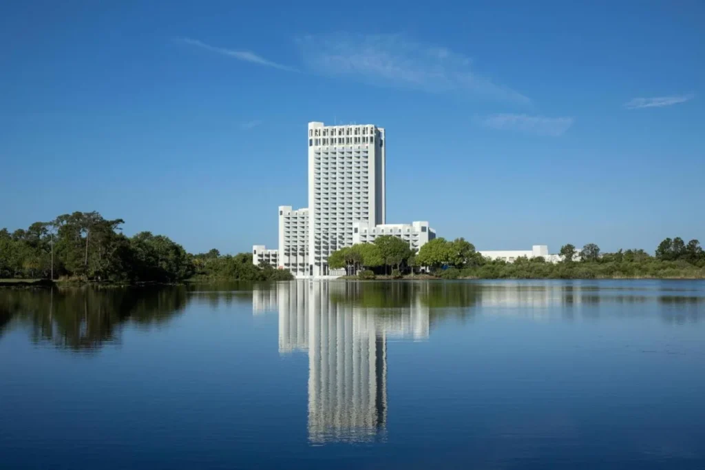 Hilton Orlando Buena Vista Palace tower reflected in a calm lake under blue sky