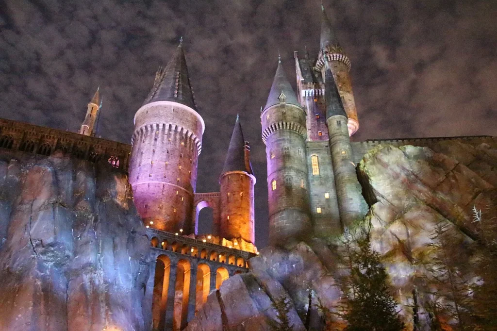Hogwarts castle lit up at night above rocky cliffs at Universal Islands of Adventure