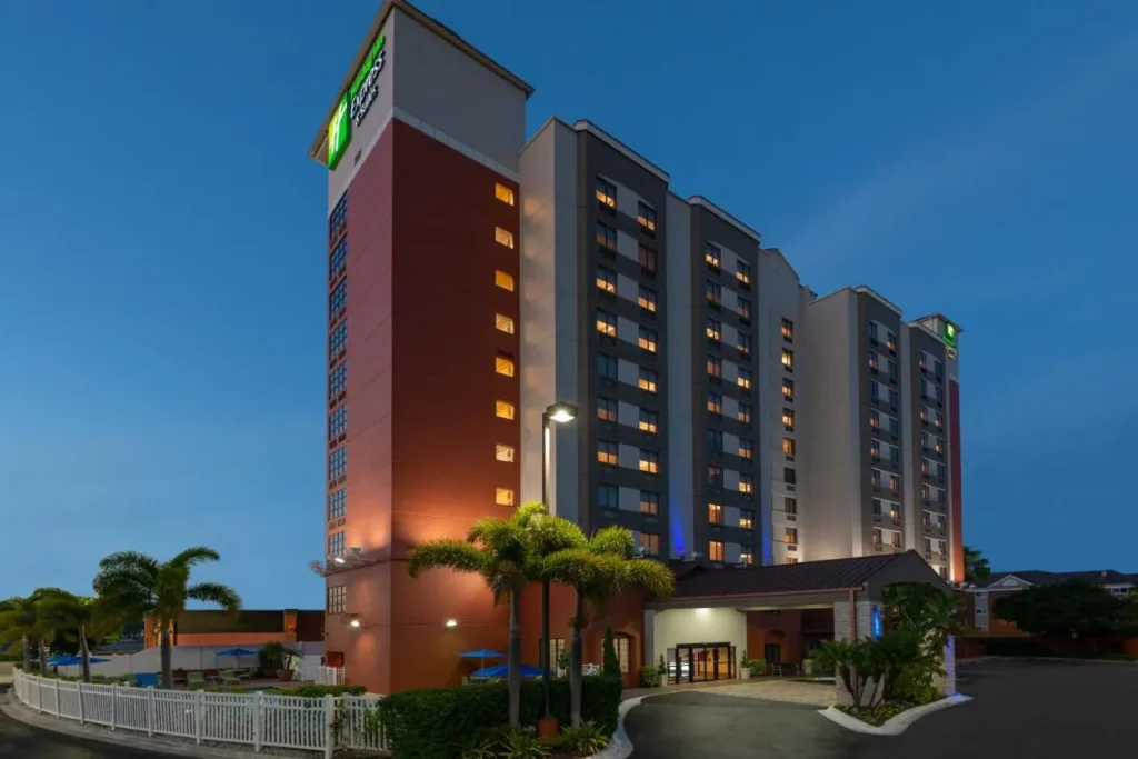 Holiday Inn Express Nearest Universal Orlando tower and covered entrance lit at dusk