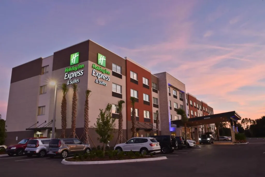 Holiday Inn Express & Suites Orlando Southeast edificio y estacionamiento al atardecer