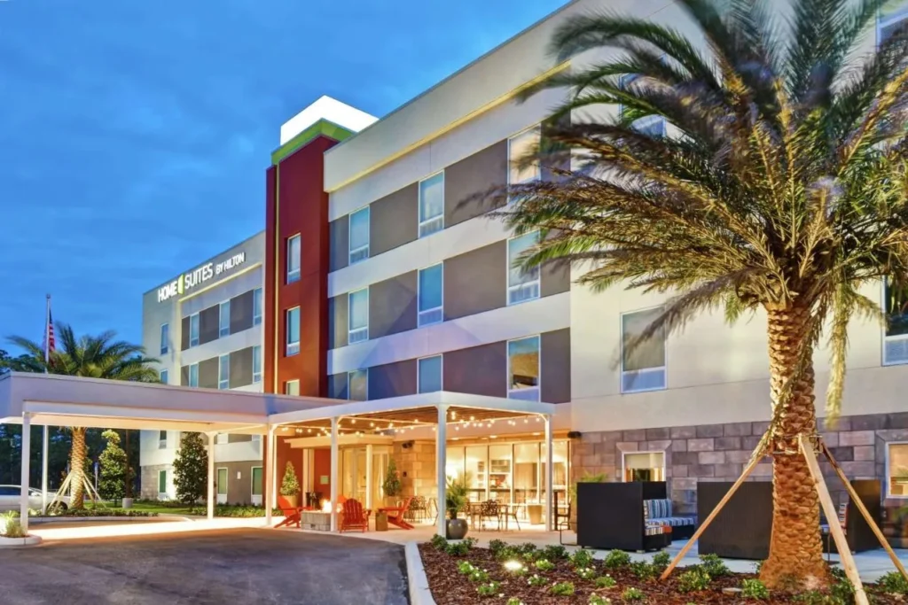 Home2 Suites Daytona Beach Canopy de entrada y patio al atardecer con una palmera