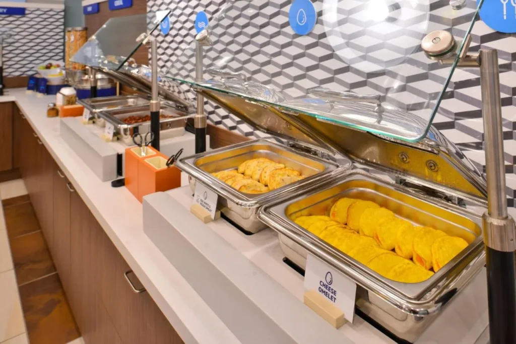 Hot breakfast buffet with omelets in chafing dishes at Holiday Inn Express Nearest Universal Orlando
