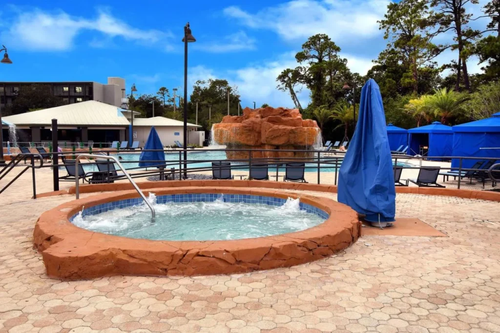 Ba&ntilde;era de hidromasaje junto a la piscina de cascada de roca y caba&ntilde;as en Wyndham Garden Lake Buena Vista