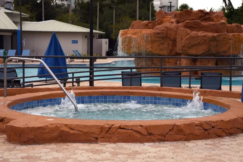Ba&ntilde;era de hidromasaje junto a la piscina de cascada de roca en el &aacute;rea de Oasis en Wyndham Lake Buena Vista
