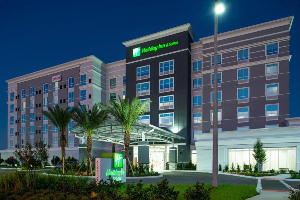 Exterior del hotel y letrero de entrada al atardecer en Holiday Inn & Suites Orlando I-Drive Theme Parks