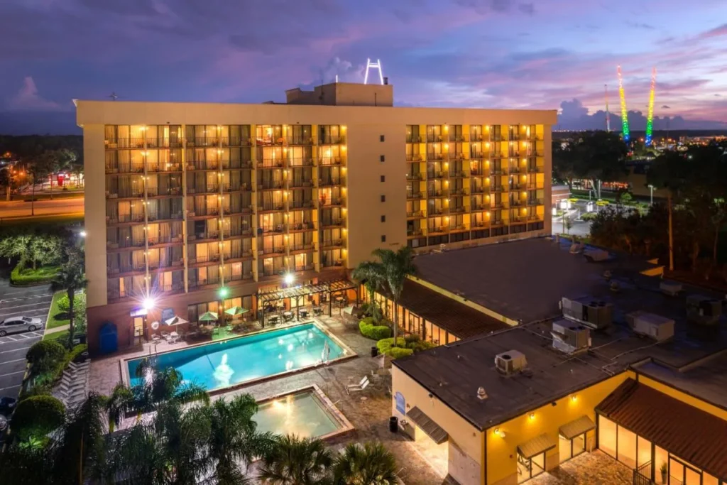 Hotel tower and pools at dusk at Holiday Inn & Suites Orlando SW Celebration Area