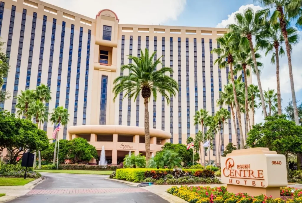 Torre del hotel, entrada con palmeras y letrero de entrada en Rosen Centre Hotel