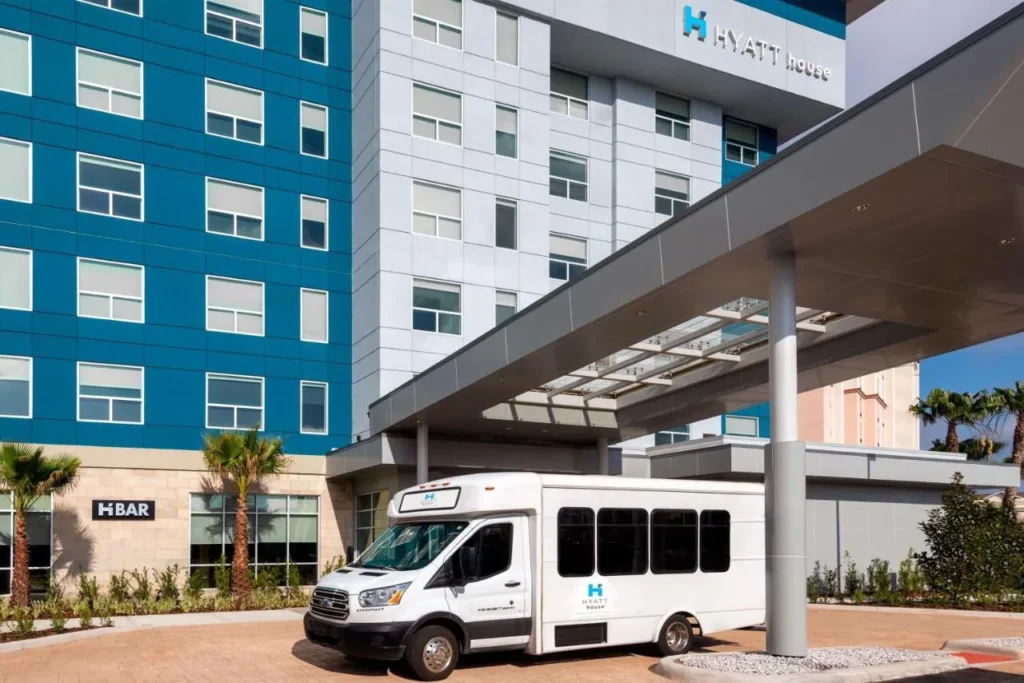 Hyatt House Orlando Airport shuttle bus waiting under the entrance canopy of the hotel