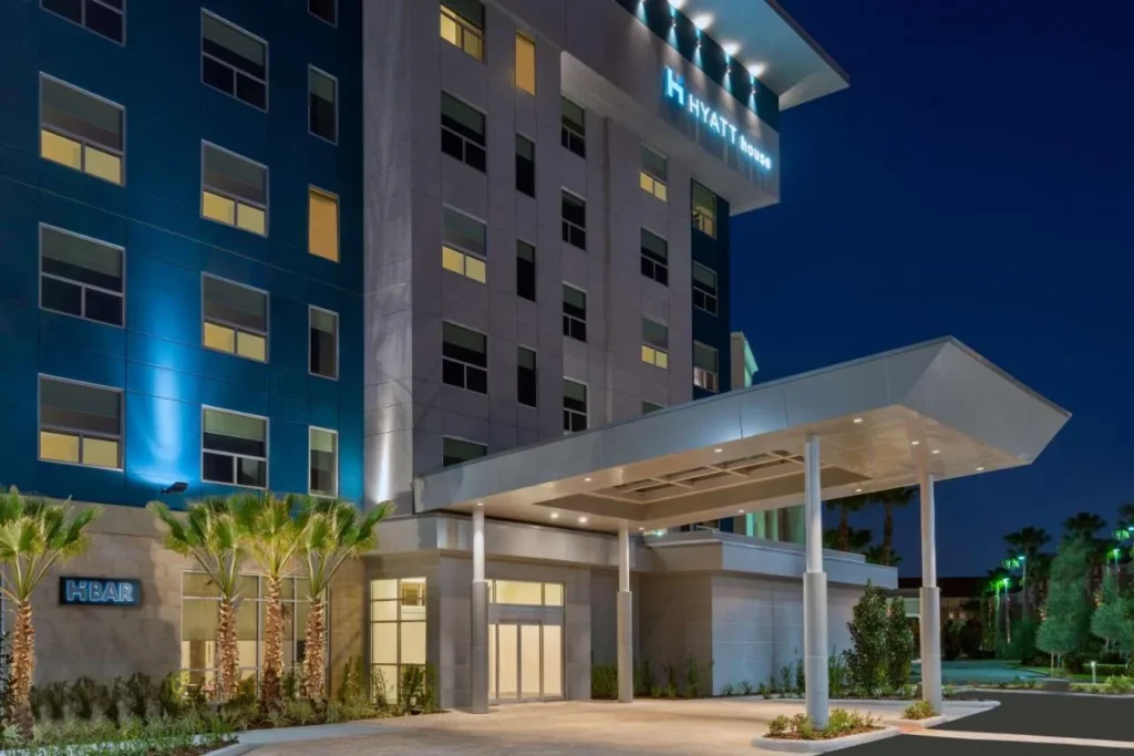 Torre Hyatt House Orlando Airport y dosel de entrada iluminados al anochecer