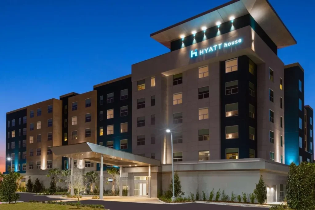 Torre Hyatt House Orlando Airport y dosel de entrada iluminados al anochecer