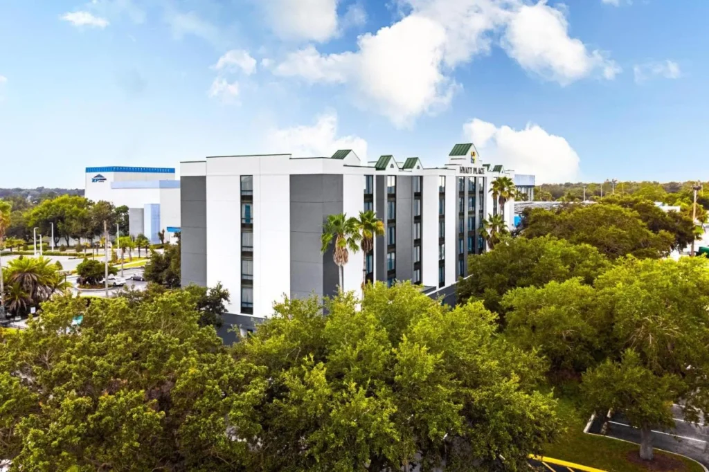 Hyatt Place Lakeland Center visto por encima de los árboles, con la arena RP Funding Center detrás de él