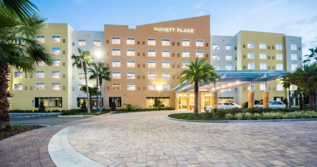 Hyatt Place Orlando/Lake Buena Vista: dosel de entrada, palmeras y entrada de ladrillo al atardecer
