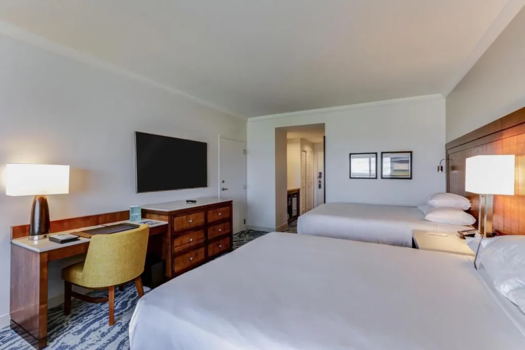 Habitaci&oacute;n de Hyatt Regency Orlando con dos camas queen, escritorio y televisor de pared