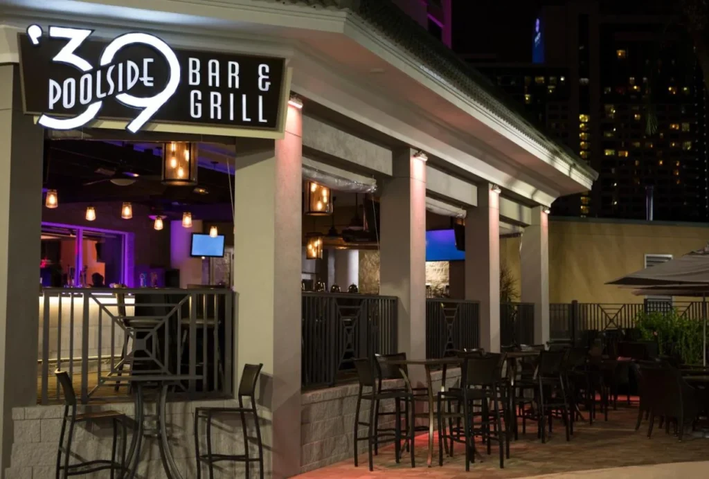 Illuminated '39 Poolside Bar and Grill with outdoor seating at night, Rosen Plaza Hotel