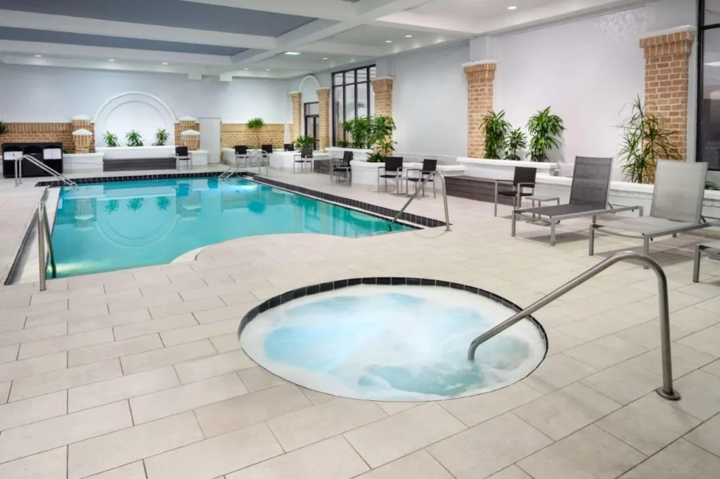 Indoor pool and round whirlpool with lounge chairs at Embassy Suites by Hilton Orlando North