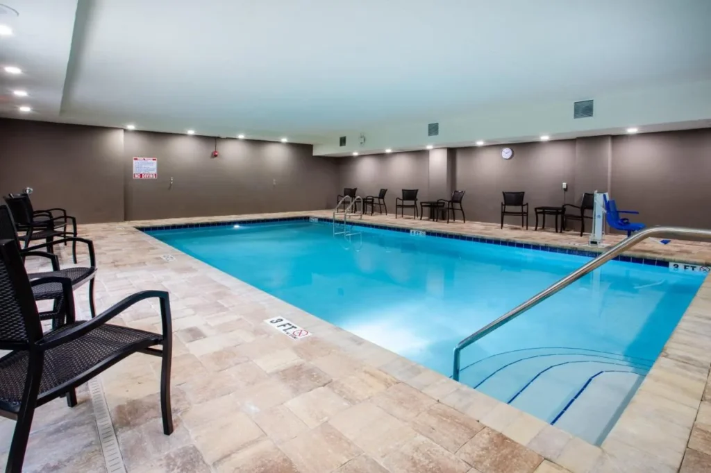 Indoor swimming pool with chairs and a pool lift at Holiday Inn Express Deland South