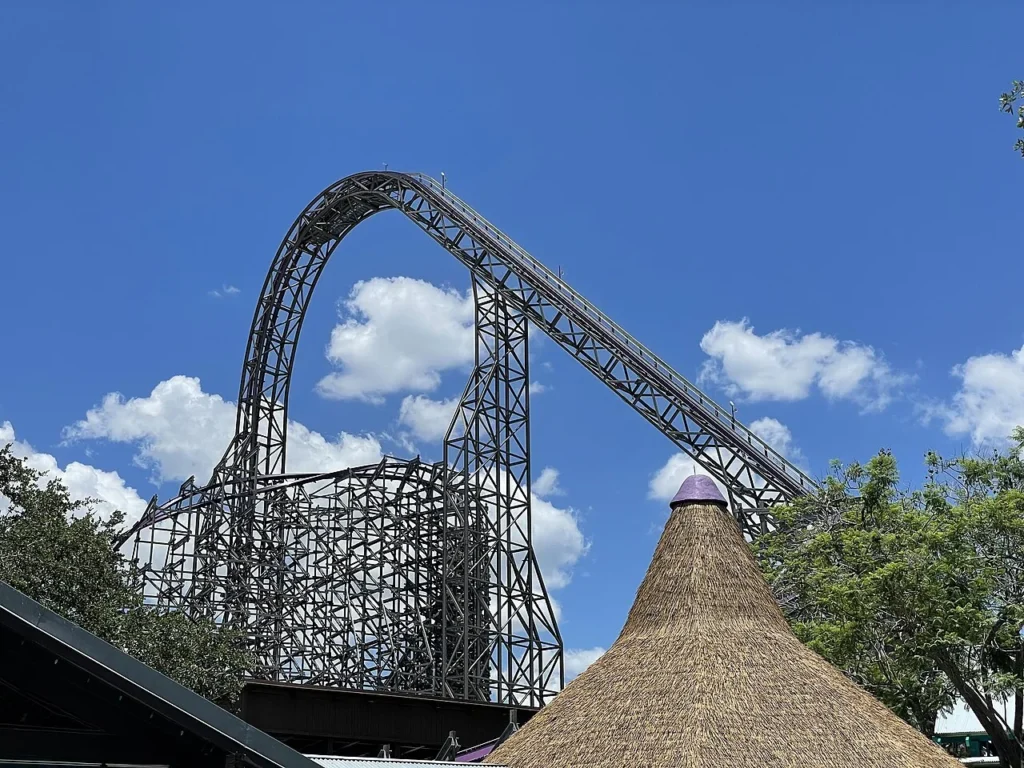 Iron Gwazi roller coaster track rising above a thatched roof at Busch Gardens Tampa Bay