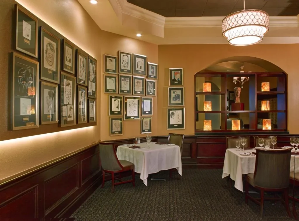 Jack's Place dining room with framed caricatures and set tables at Rosen Plaza Hotel