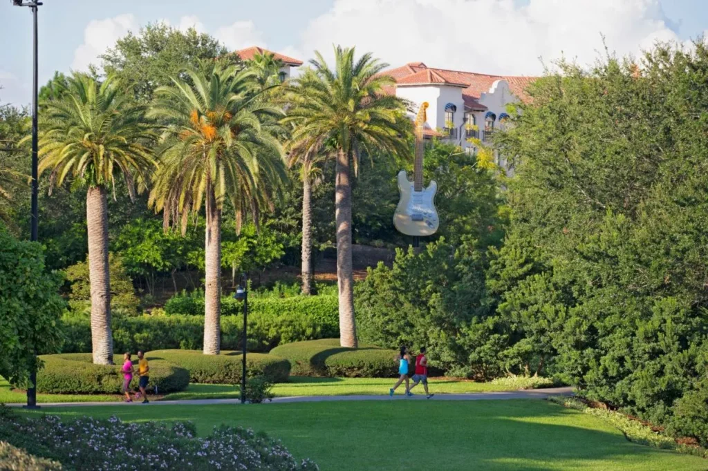 Corredores en el camino del jard&iacute;n con palmeras debajo de una guitarra gigante en Hard Rock Hotel Orlando