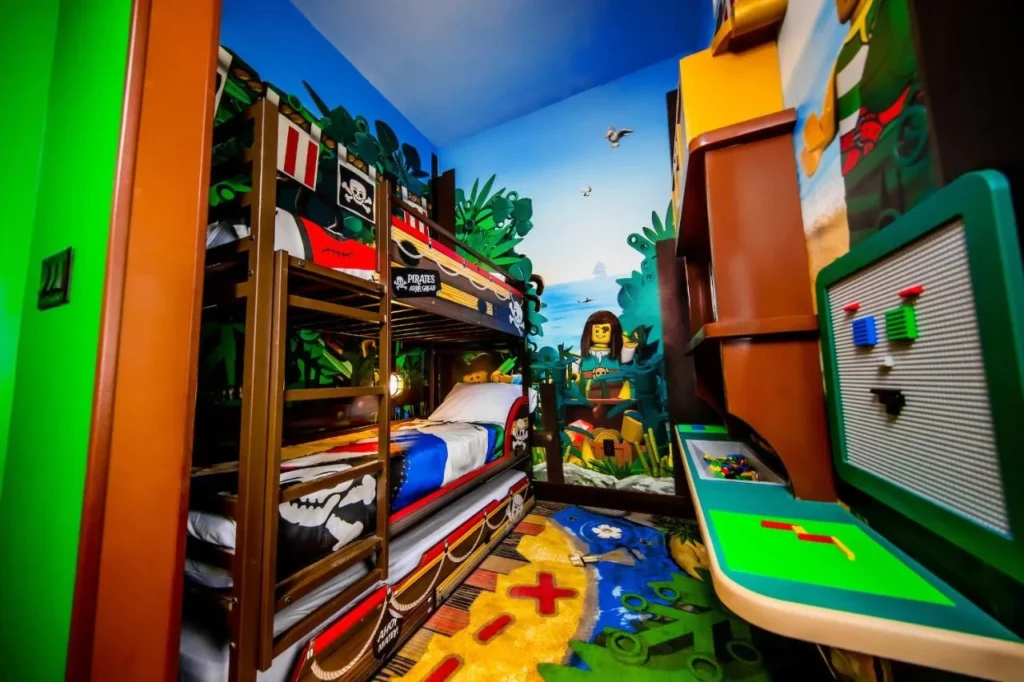 Kids' sleeping area with bunk bed, trundle and LEGO building table at Pirate Island Hotel