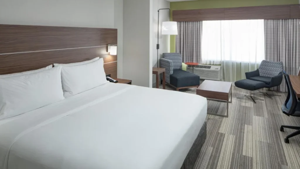 Cama king y zona de estar con sill&oacute;n en Holiday Inn Express & Suites Orlando at SeaWorld