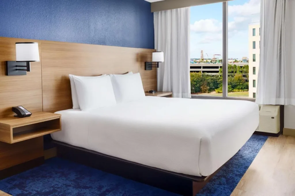 Cama King junto a una gran ventana con vista a la ciudad en Hyatt Place across from Universal