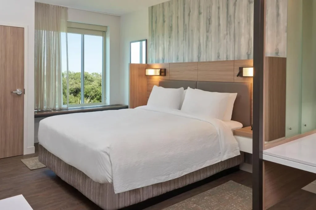 Cama King junto a una ventana con vistas al &aacute;rbol en el SpringHill Suites Orlando Lake Nona