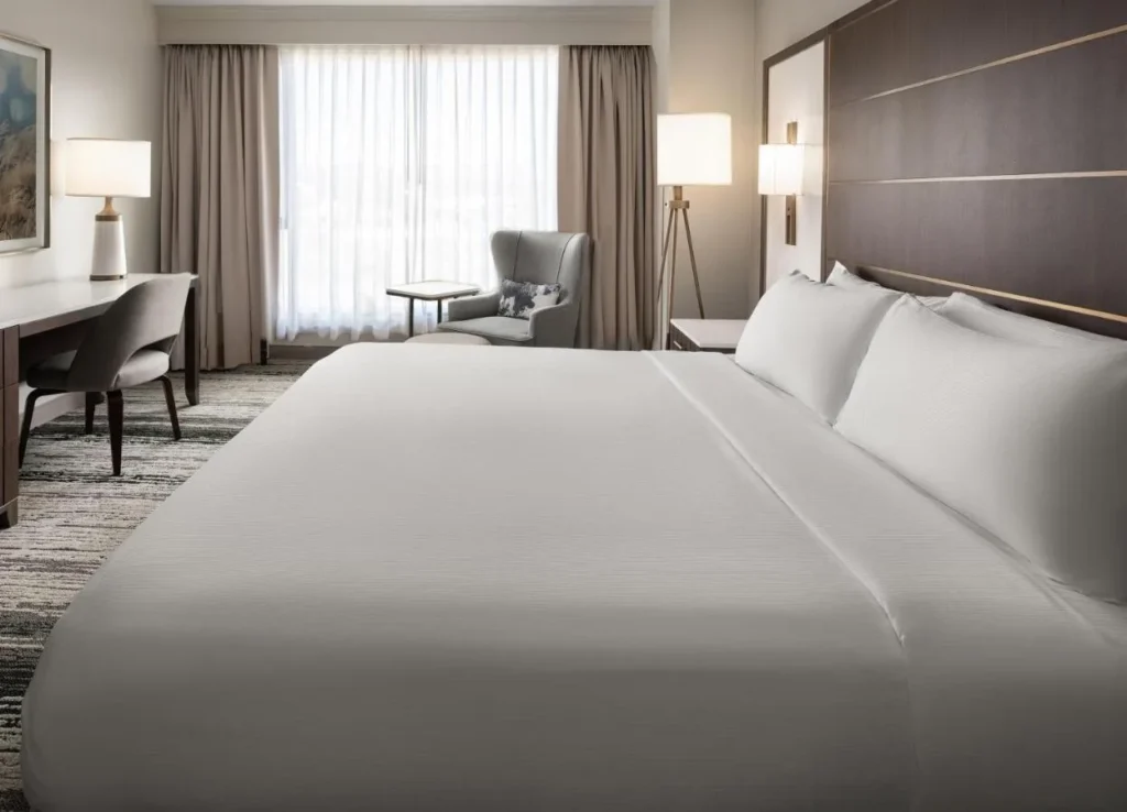 Cama King, escritorio y sillón en una habitación en Signia by Hilton Orlando Bonnet Creek