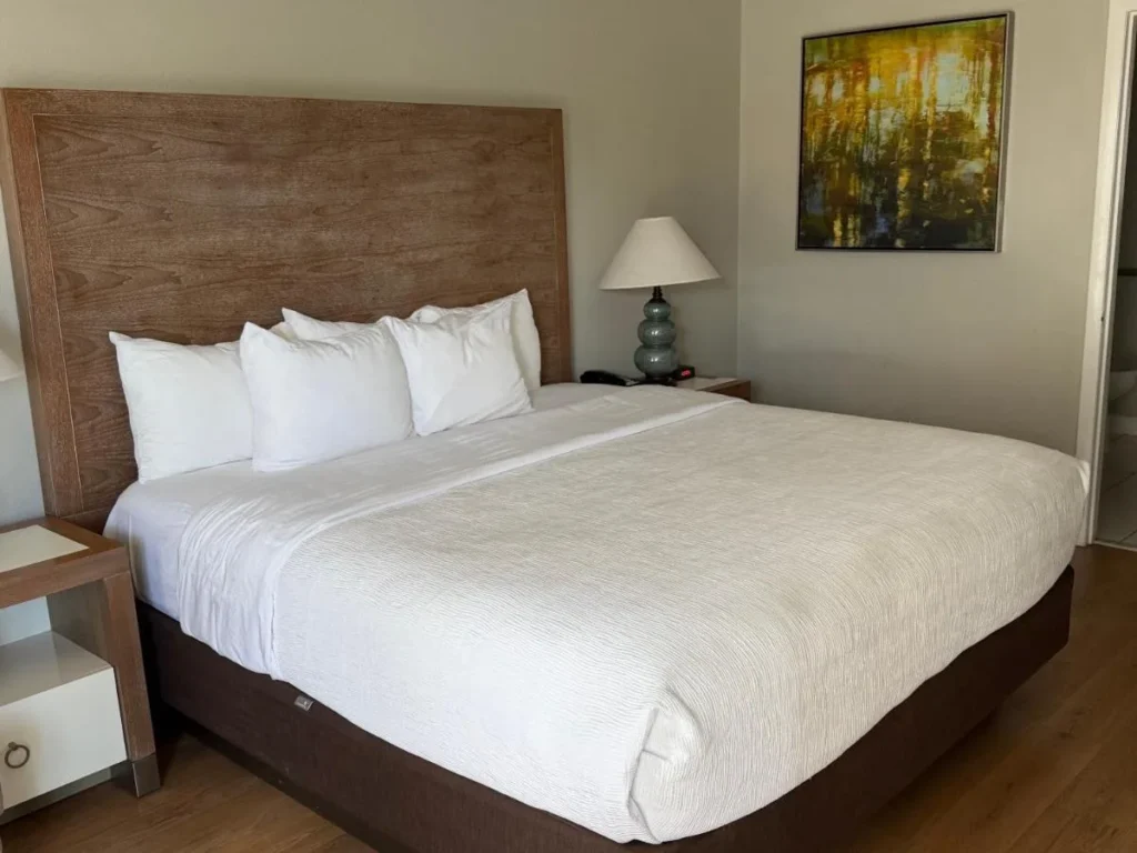 Cama King con cabecero de madera en Quality Inn & Suites By the Parks