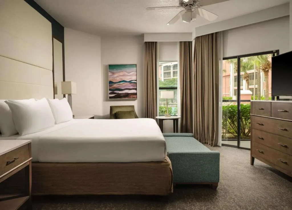 Habitaci&oacute;n King en Caribe Royale Orlando con vestidor, TV y puertas correderas a un patio