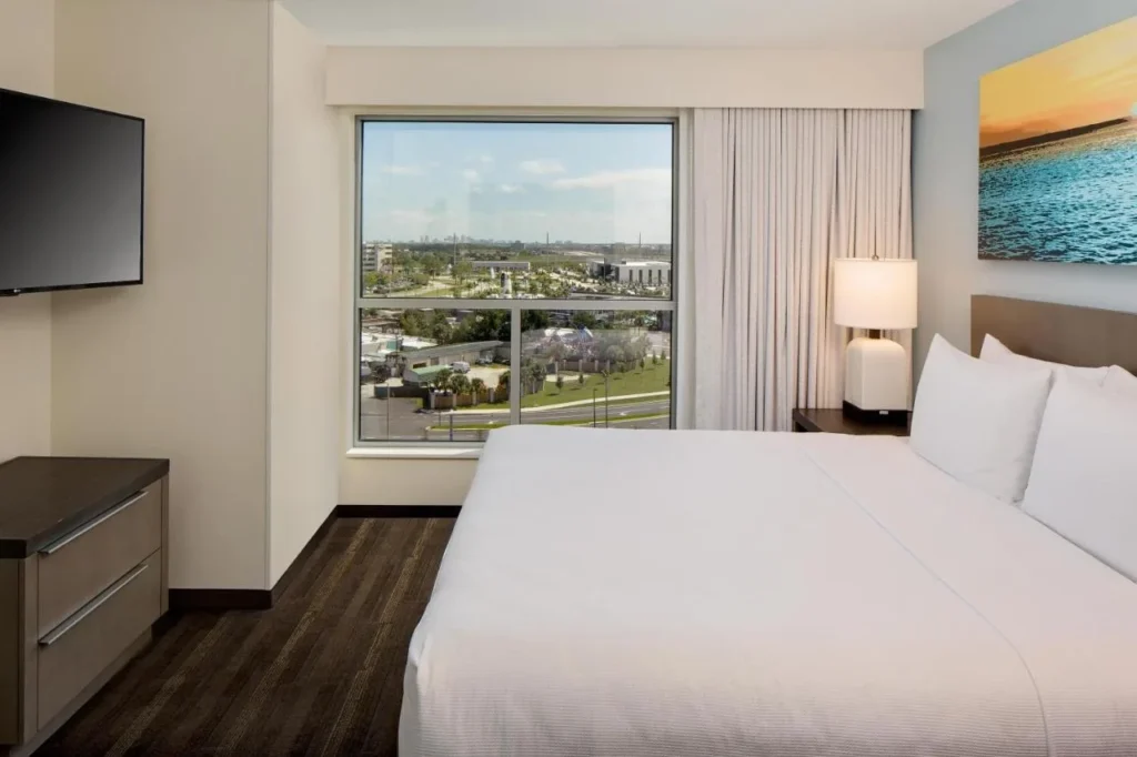 King bedroom with a picture window and city view at Hyatt House across from Universal