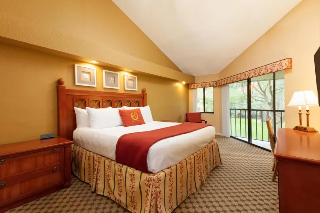 King bedroom with vaulted ceiling and balcony doors in a villa at Westgate Vacation Villas Resort