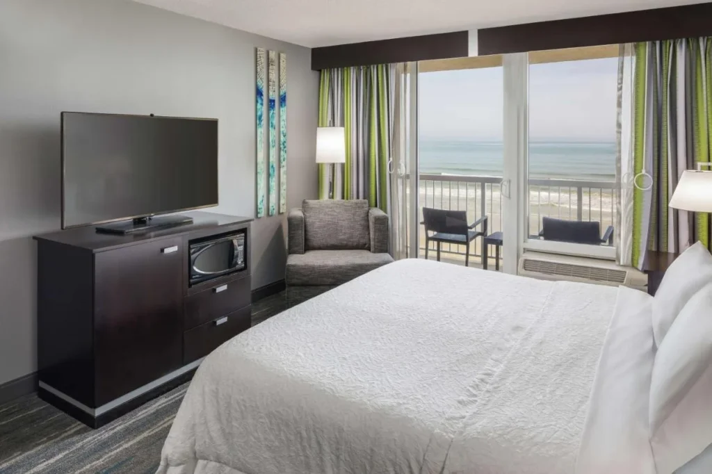 King room with a balcony door looking straight out to the ocean at Hampton Inn Daytona Beach/Beachfront