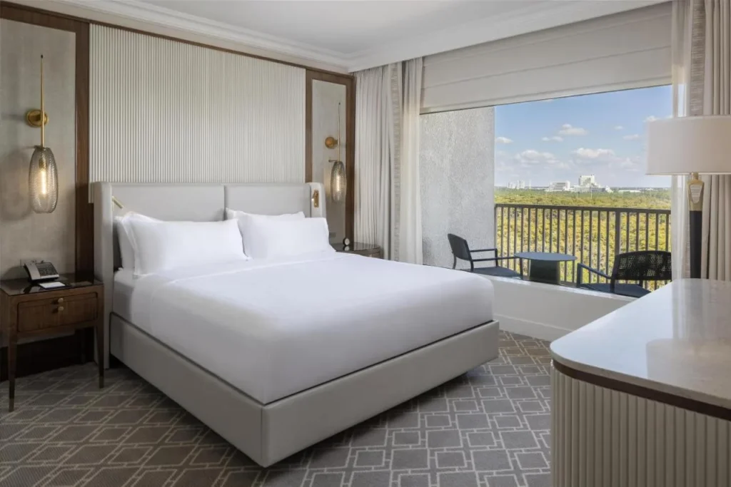 Habitaci&oacute;n con cama king y balc&oacute;n con vistas a los &aacute;rboles en Waldorf Astoria Orlando