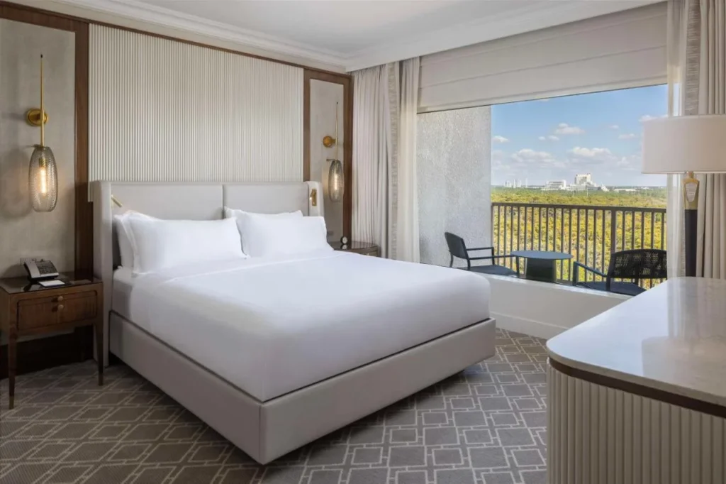 King room with a furnished balcony overlooking woods at Waldorf Astoria Orlando