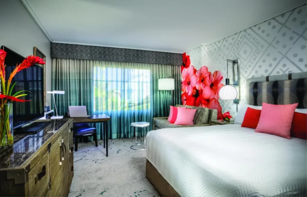 King room with a hibiscus mural and teal curtains at Loews Royal Pacific Resort