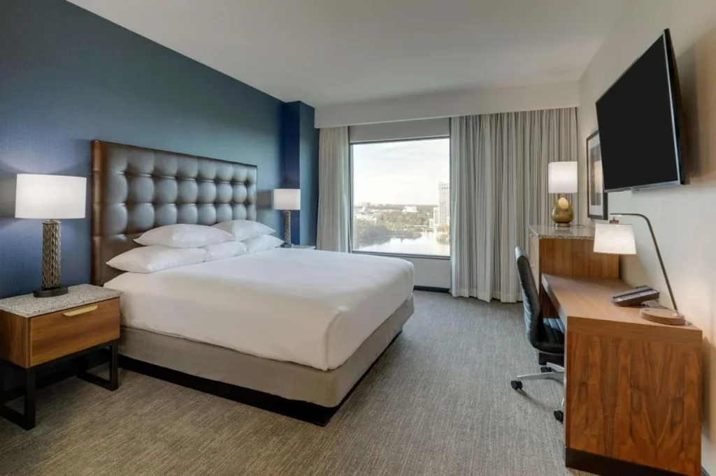 King room with a large window looking over a lake at Drury Plaza Hotel Orlando