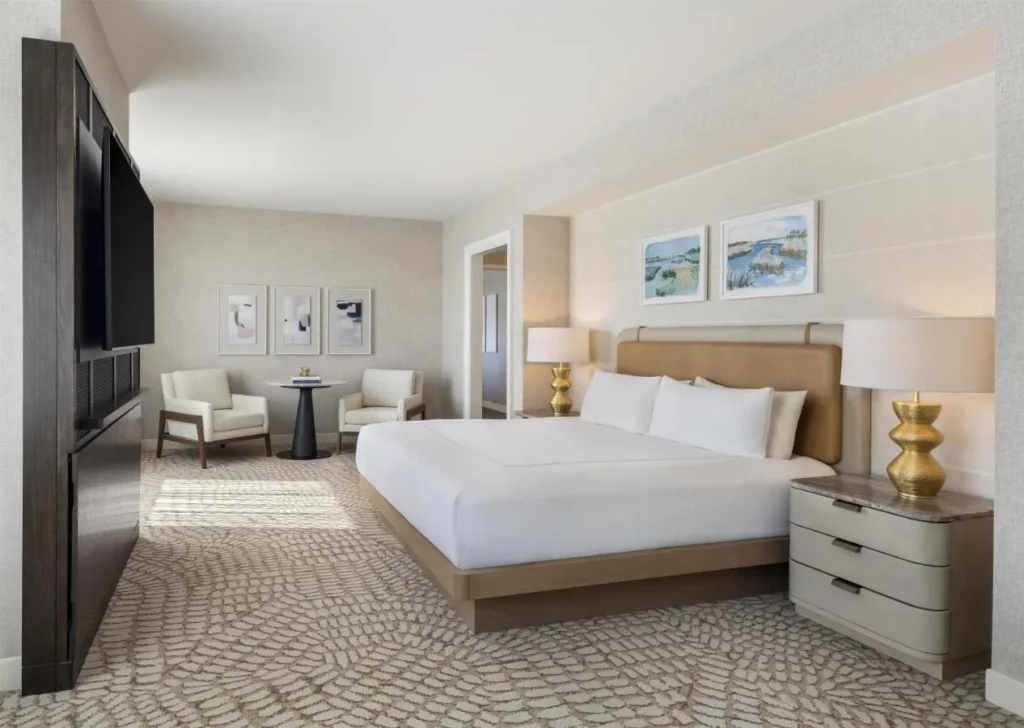 Habitaci&oacute;n King con cabecera de cuero y peque&ntilde;a sala de estar en Hilton Orlando