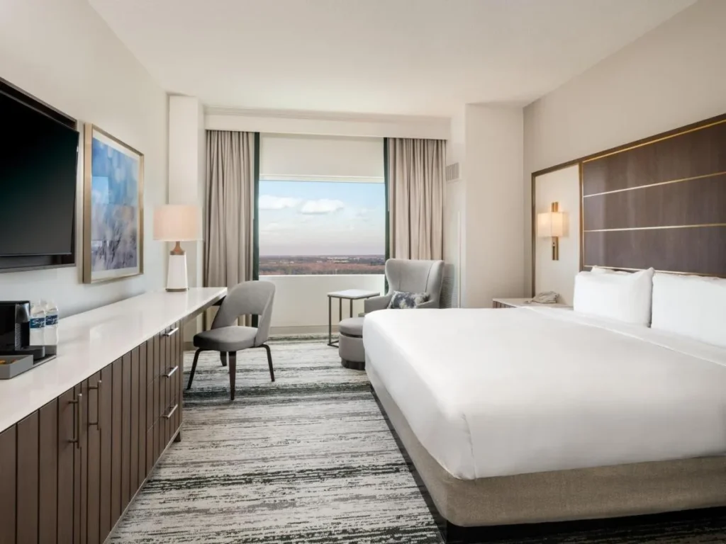 King room with a long desk, armchair and wide window at Signia by Hilton Bonnet Creek