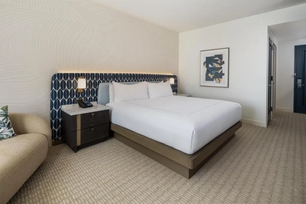 King room with a patterned headboard and lounge chair at Hilton Orlando