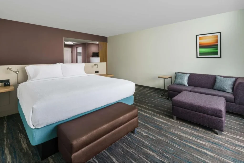 King room with a purple sofa and ottoman at Hilton Garden Inn Apopka City Center