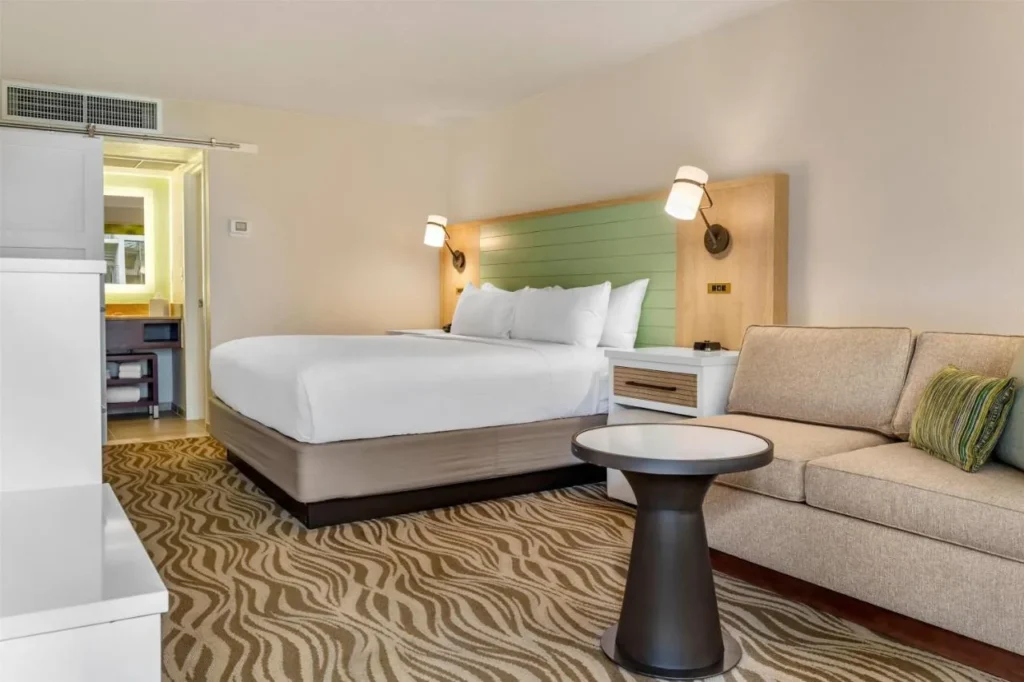 King room with a sofa and a green headboard at Wyndham Garden Lake Buena Vista