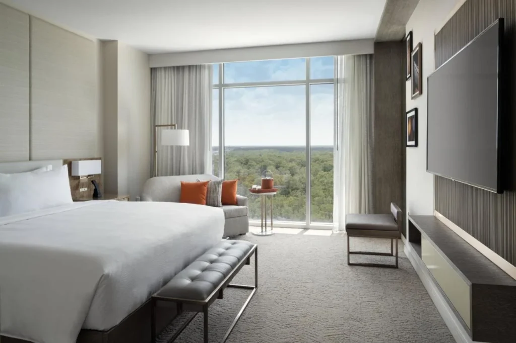 Habitaci&oacute;n King con sof&aacute; y ventana de piso a techo sobre el bosque en JW Marriott Orlando Bonnet Creek
