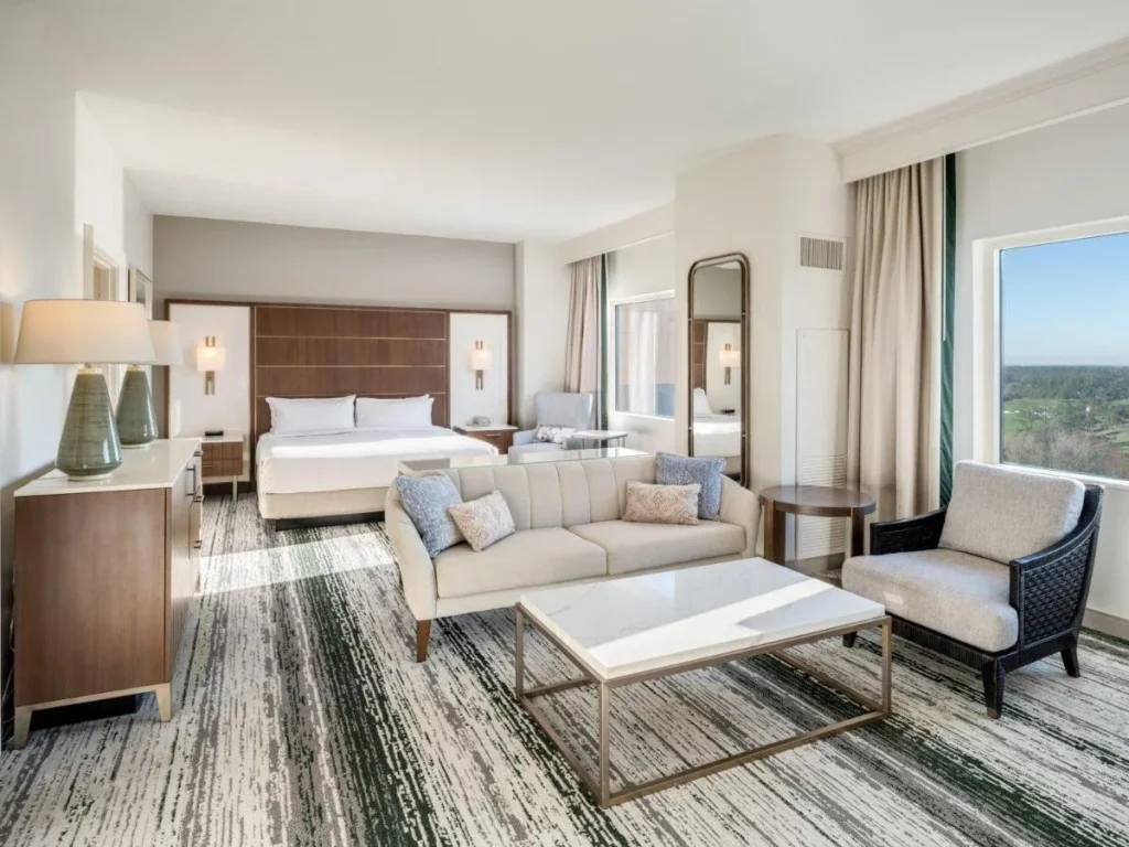 Habitación King con sofá, sillón y ventana ancha en Signia by Hilton Orlando Bonnet Creek