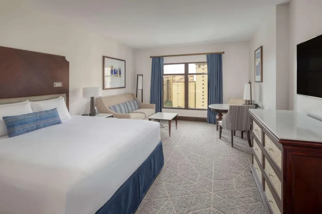 Habitación con cama king con sofá, mesa de centro y zona de trabajo en Wyndham Grand Orlando Bonnet Creek