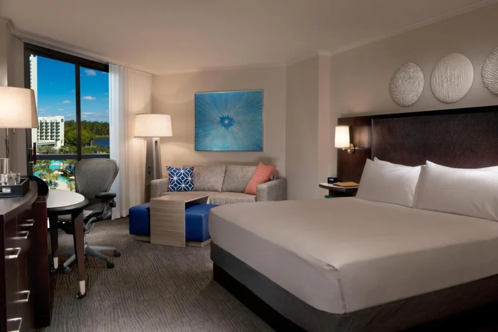 King room with a sofa, desk and pool-view window at Hilton Orlando Buena Vista Palace