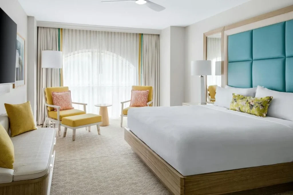 Habitación King con cabecero de color verde azulado y asientos en la ventana en Gaylord Palms Resort